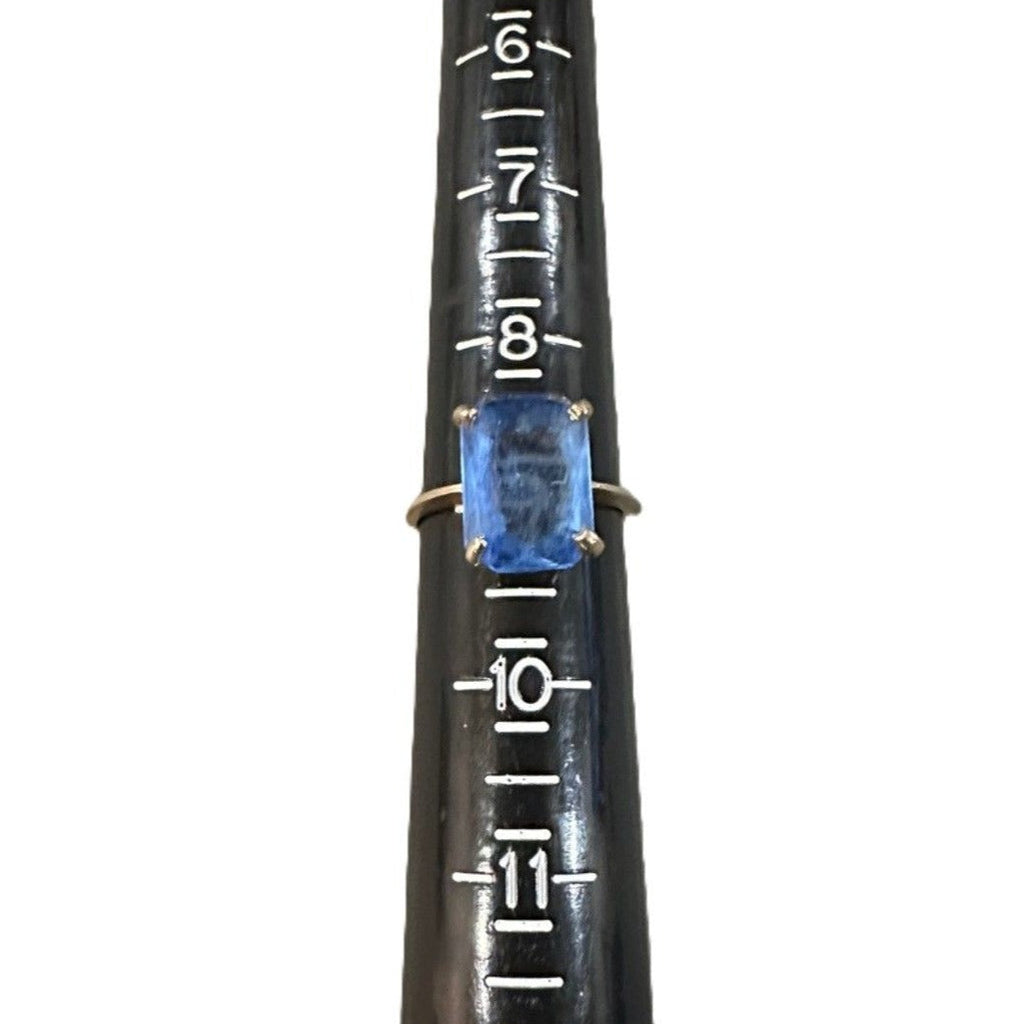 Black measuring tool with blue gemstone on a white background