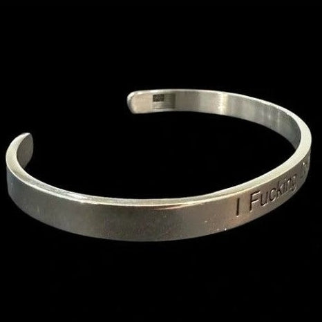Silver bracelet with engraved text on a black background