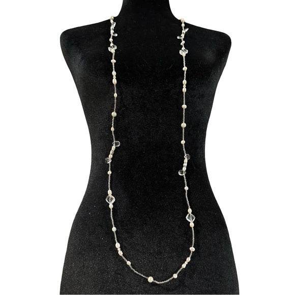 Long beaded necklace on a black mannequin against a white background