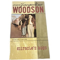 Book cover of 'Miracle's Boys' by Jacqueline Woodson with a street scene illustration.