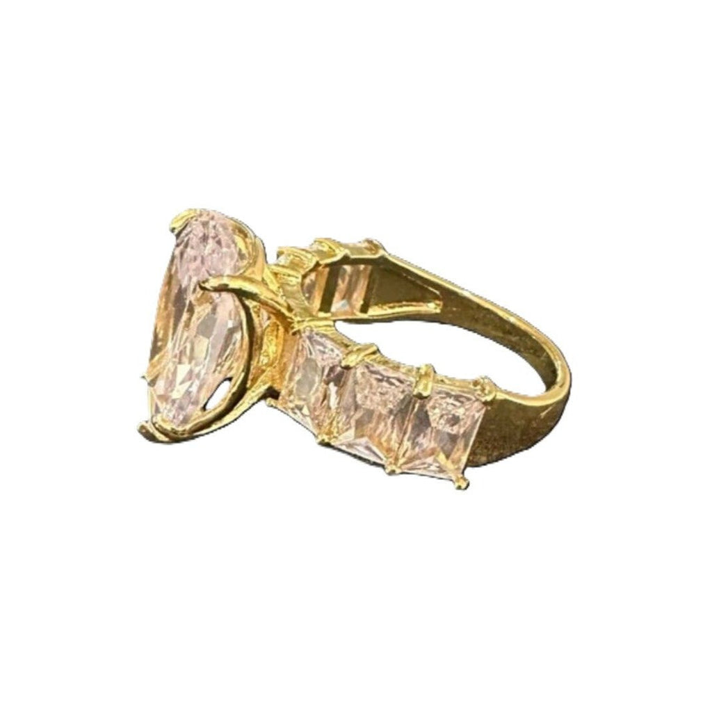 Gold ring with pink gemstone on a white background