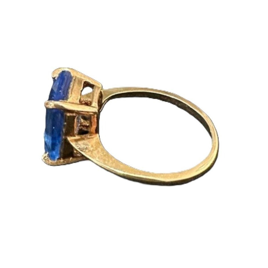 Gold ring with blue gemstone on a white background