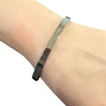 Silver bracelet on a wrist with a white background