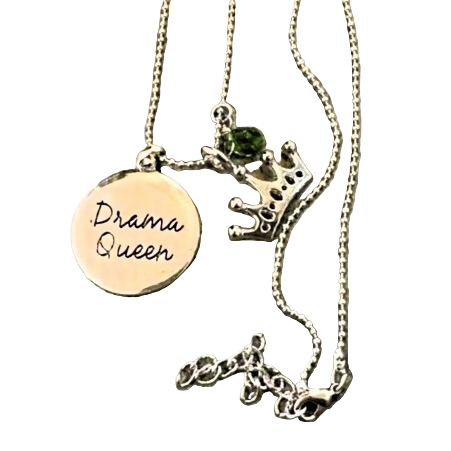 Necklace with 'Drama Queen' pendant on a textured surface