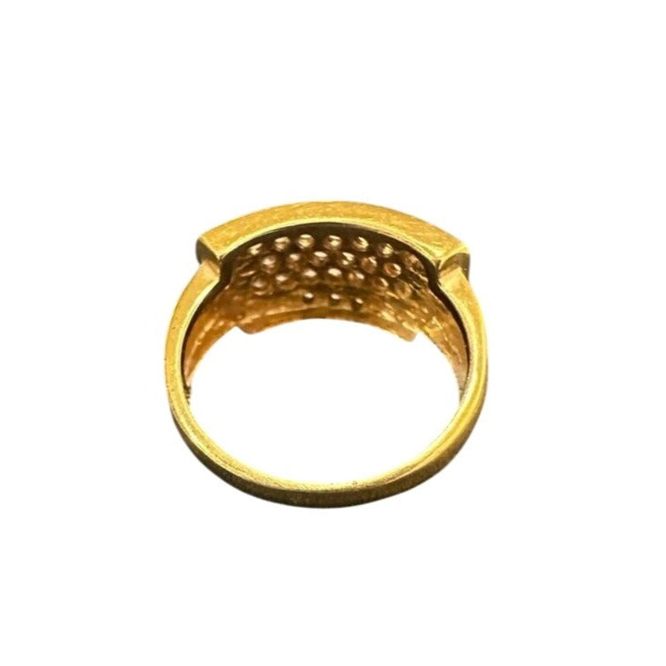 Gold ring with textured design on a white background