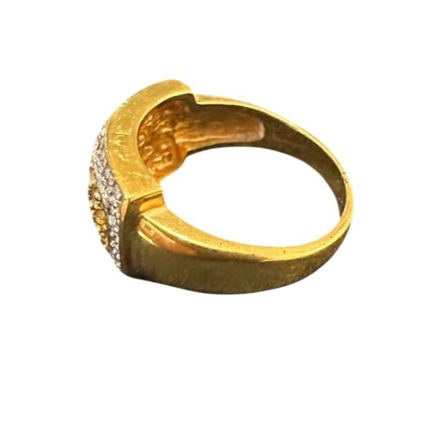Gold ring with textured band and diamond-studded design on a white background