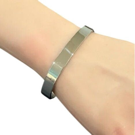Silver bracelet on a wrist against a white background