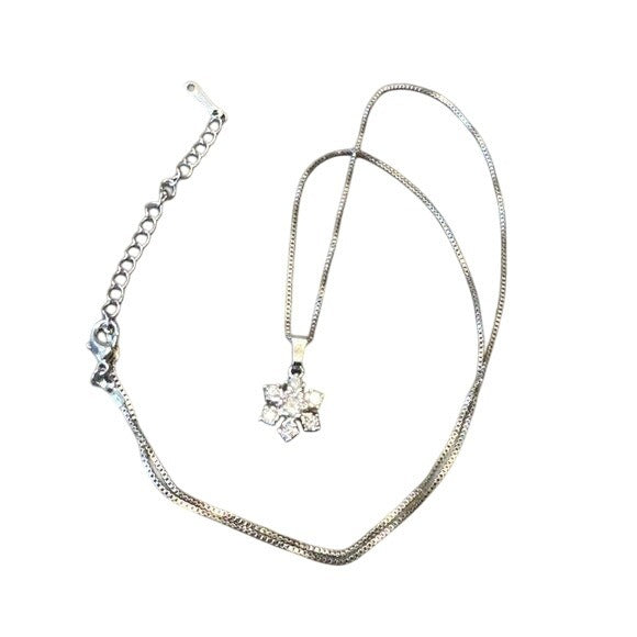Silver necklace with a star-shaped pendant on a white background