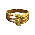 Gold ring with green gemstones on a white background