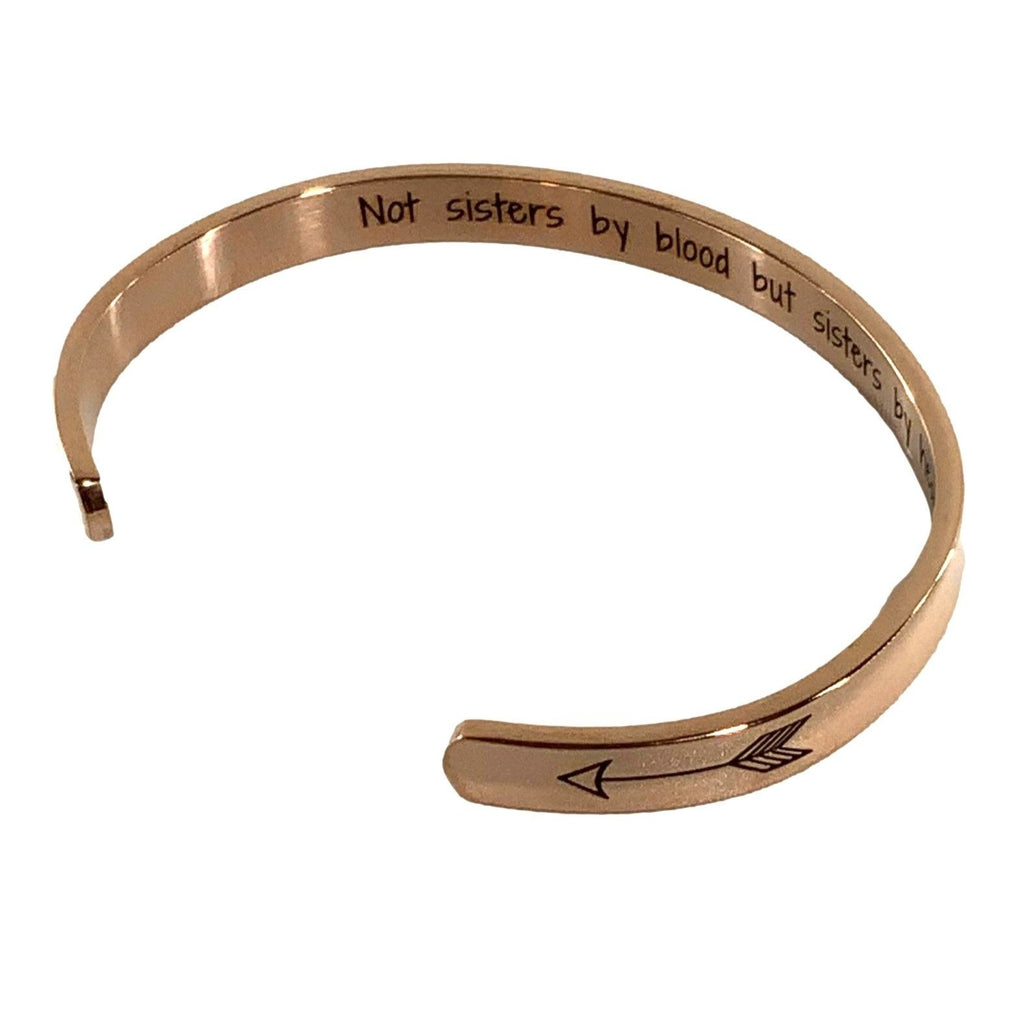Rose gold bracelet with engraved text and arrow design on a white background