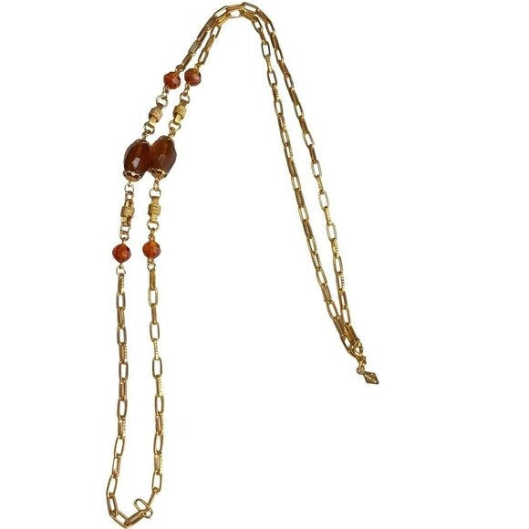 Gold chain necklace with brown beads on a white background