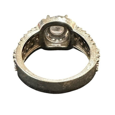 Silver ring with a central gemstone on a white background