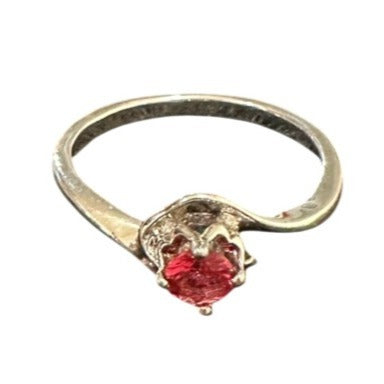 Gold ring with a red gemstone on a white background