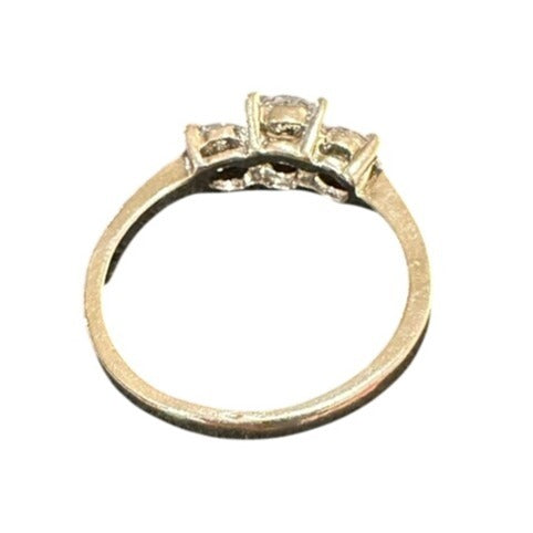 Gold ring with three diamond stones on a white background