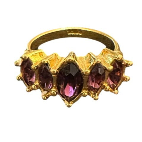 Gold ring with purple gemstones on a white background
