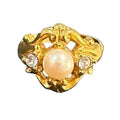 Gold ring with a pearl and small crystals on a black background