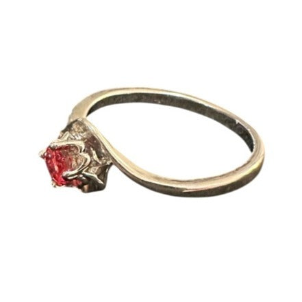 Gold ring with a red gemstone on a white background